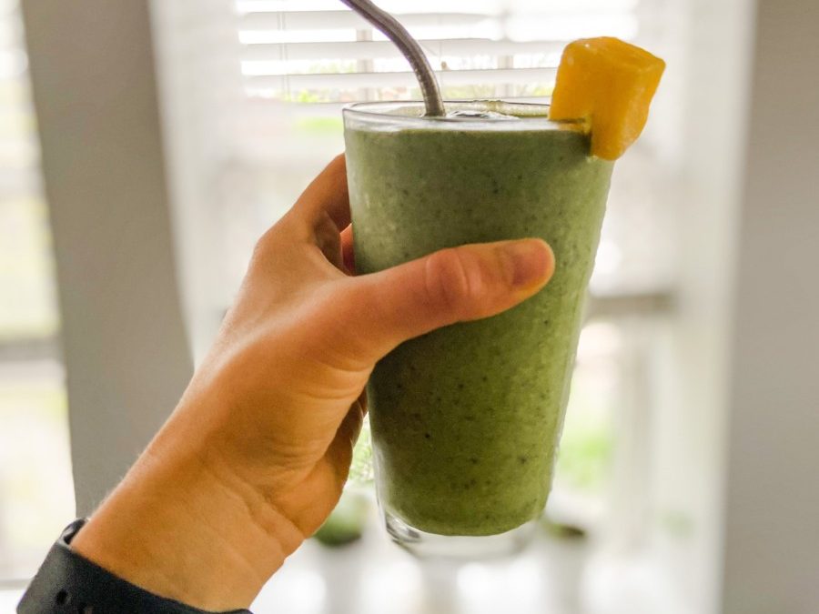 green smoothie, green drink, drink in front of window, drink with fruit on edge